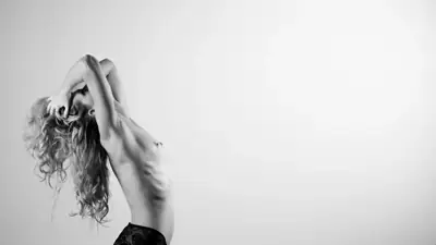 Woman with her head tilted back and hair falling behind her, in black and white