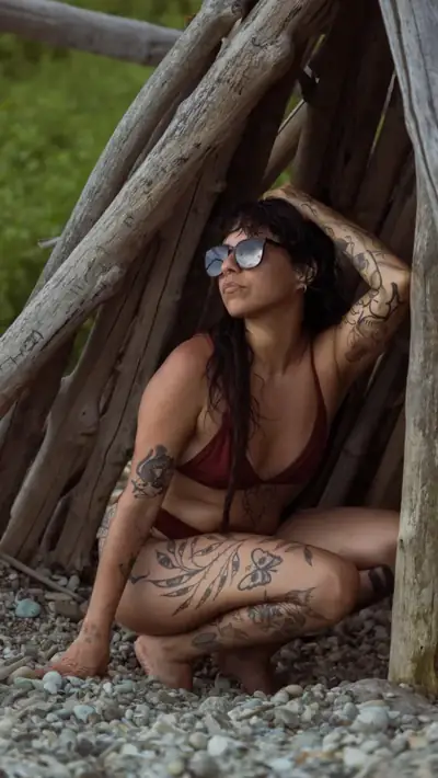 Woman in sunglasses sitting among exposed tree roots
